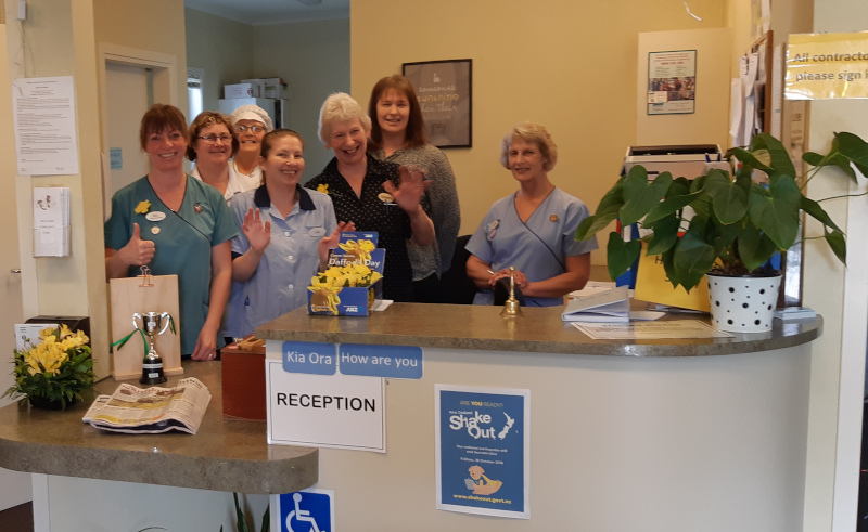 Wyndham and Districts Community Rest Home staff group photo waving.