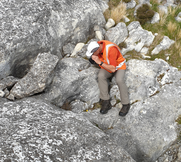 MainPower New Zealand Limited employee inspecting rocks.