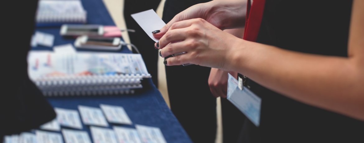 Process of checking in on a conference congress forum event, registration desk table, visitors and attendees receiving a name badge and entrance wristband bracelet and register the electronic ticket binary comment